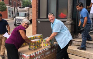 Staff help each other bring pallets of food into the Family Support Center where people receive help with basic needs assistance.
