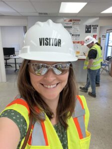Katie Anderson, VP of Acute Services, enters facility with hard hat and safety glasses.